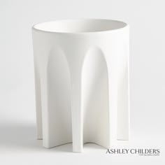 a white vase sitting on top of a table