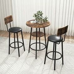 three stools and a table in front of a white curtain