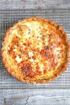 a baked pizza sitting on top of a metal rack next to a knife and fork