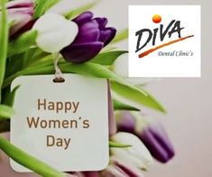 a happy women's day sign hanging from a bouquet of tulips with purple and white flowers in the background