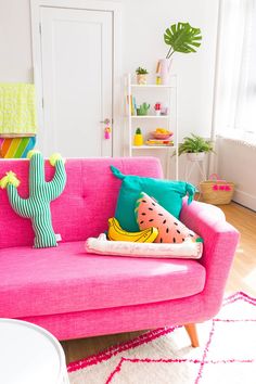 a pink couch with colorful pillows on it