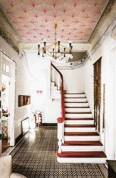 a staircase leading up to the second floor in a house with red and white decor