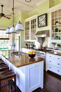 a kitchen with white cabinets and an island in the middle is filled with oranges