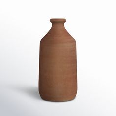 a brown vase sitting on top of a white surface