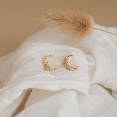 These versatile, celestial earrings embody the magic of the moon. Inspired by the beauty of the night sky with its crescent moon and starry diamond accents, our Eclipse Moon Diamond & Pearl Earrings are an eye-catching pair that will allow you to shimmer from day to night ✨ Material: High Quality Solid 925 Sterling Silver Finish: Sterling Silver ∙ 18K Gold Featuring ~9.5mm x 11mm Crescent Moon & Star Stud Earrings with CZ Diamond and Pearl Gemstones | Sold as a Pair SKU: RR-ER254 Celestial Half Moon Earrings With Moon Phase Detail, Celestial Crescent Single Earring, Single Crescent Celestial Earring, Elegant Crescent Moon Charm Earrings, Celestial Yellow Gold Cubic Zirconia Earrings, Elegant Half Moon Earrings With Moon Charm, Elegant Crescent Hoop Earrings With Moon Charm, Elegant Moon Phase Earrings, Elegant Yellow Gold Moon Phase Earrings