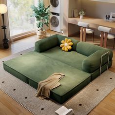 a large green couch sitting on top of a wooden floor