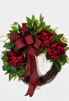 a wreath with red flowers and green leaves