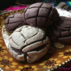 some cookies are on a plate with brown icing