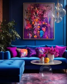 a living room with blue couches and colorful pillows on the sofa, in front of a large painting