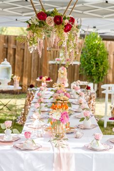 a long table covered in lots of food and flowers on top of white linens