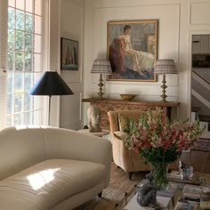 a living room filled with furniture and a painting on the wall