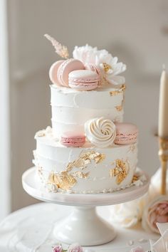 a three tiered white cake with pink and gold decorations