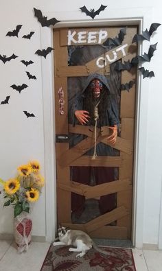 a door decorated with fake bats and a creepy doll