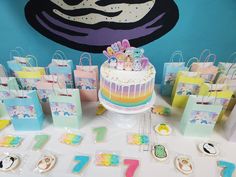 there is a cake and many bags on the table at this children's birthday party