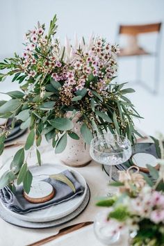 the table is set with flowers and plates