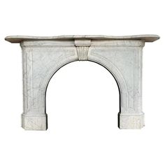 a white marble fireplace mantel with an arch