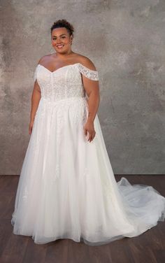 a woman in a white wedding dress posing for the camera with her hands on her hips