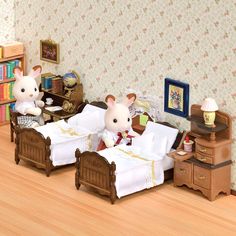 two toy mice sitting on twin beds in a room