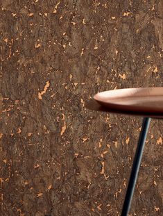 a close up of a table with a wooden top and metal legs in front of a brown wall