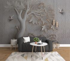 a living room with a couch, coffee table and tree wall mural on the wall