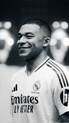 a man smiling while wearing a soccer jersey