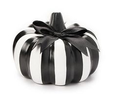 a black and white striped pumpkin with a bow on it's top, sitting in front of a white background