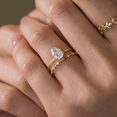 a woman's hand with two gold rings and one diamond ring on her finger