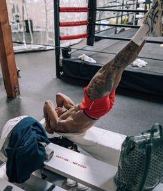 a man doing a handstand in a boxing ring with his leg up on the ground