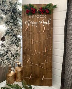 a wooden sign that says the poos merry mail on it next to a christmas tree