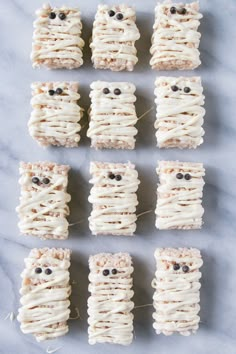 an assortment of treats made to look like faces and eyes are arranged in rows on a marble surface