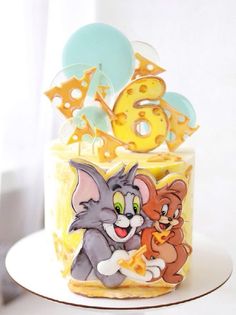 a birthday cake decorated with cartoon characters on it's top and the number six