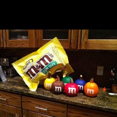 a bag of m & m's sitting on top of a counter next to some candy