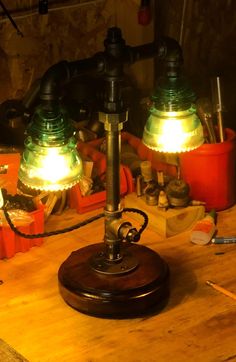 two green and red lamps sitting on top of a wooden table next to other items