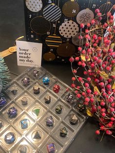 a bunch of buttons sitting on top of a table next to a card and tree