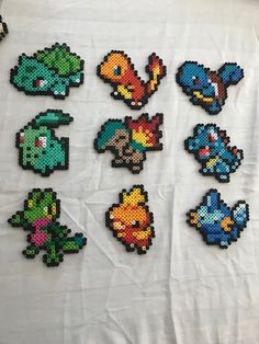 a bunch of pixel art pieces on a white tablecloth with some type of artwork