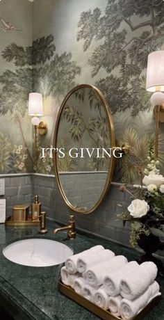 a bathroom with green marble counter tops and wallpapered walls, it's giving