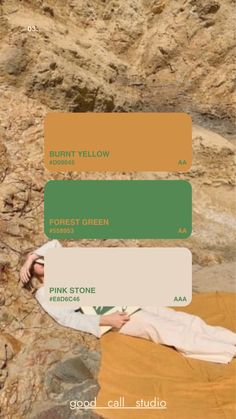 a woman laying on top of a rock covered in green and orange paint swatches