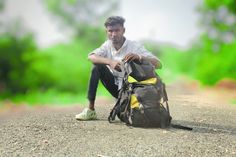 a man sitting on the ground next to a bag