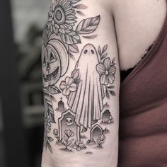 a woman with a tattoo on her arm has a sunflower and a ghost in the background