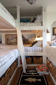 two bunk beds in a room with baskets on the floor and other items under them