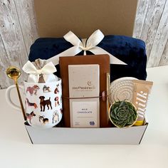 a gift box with coffee, cookies and other items in it sitting on a table