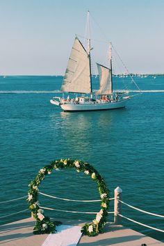 a sailboat in the water with a wreath on it's side and another boat in the background