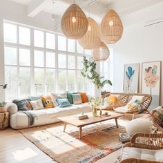 a living room filled with lots of furniture and large windows covered in wicker lamps