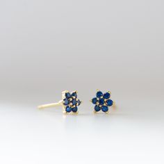 Dainty flower shaped stud earrings. Perfect for pairing with multiple piercings. Available in ALL sapphire or with a White CZ Stone in the Center DETAILS * Thick plating of 14k Gold or Rhodium over 925 Sterling Silver * Sold as a Pair * Hypoallergenic and nickel-free * 5 mm x 5 mm * Also available in white cz, ruby, emerald or black cz * Highest Grade cz for an authentic look Baguette Studs on Model: https://www.etsy.com/listing/858625085/emerald-baguette-earrings-baguette-studs?ref=shop_home_ac Baguette Earrings, Baguette Studs, Baguette Earring, Multiple Piercings, Sapphire Earrings Studs, Sapphire Studs, Birthstone Earrings, Ruby Emerald, Tiny Studs