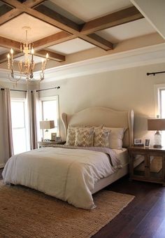 a bedroom with a bed, chandelier and two lamps on the side tables