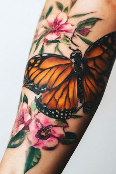 a woman's arm with an orange butterfly and pink flowers on the left side