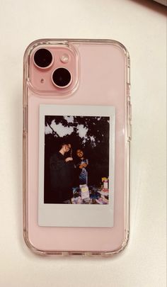 an iphone case with two photos attached to the back of it, sitting on top of a table