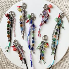 a white plate topped with lots of different types of beads and keychain charms