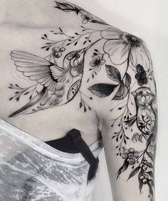 the back of a woman's shoulder with flowers and hummings on her arm