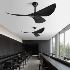 the ceiling fans are hanging from the ceiling in this modern dining room with black tables and chairs